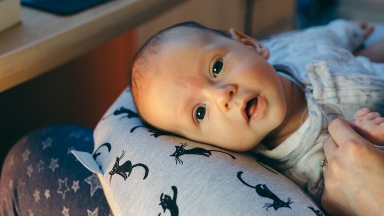 A woman is holding a baby in her arms.