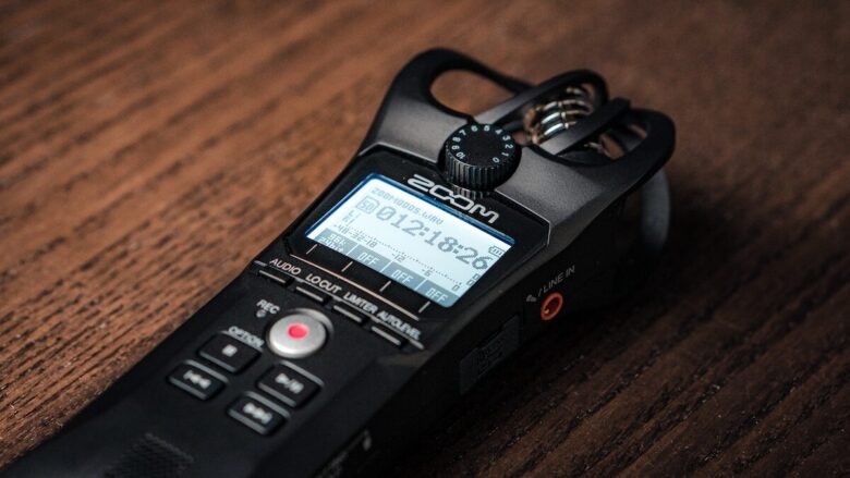 A digital recorder sitting on top of a wooden table.